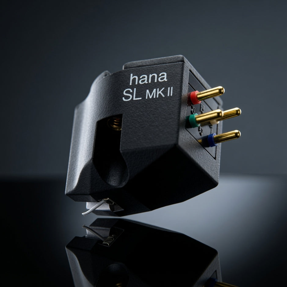 A Hana SL MK II turntable phono cartridge shown in a close-up studio shot against a dark gradient background. The cartridge is black with white printed text and features gold-plated pins with red, green, and blue shielding rings.